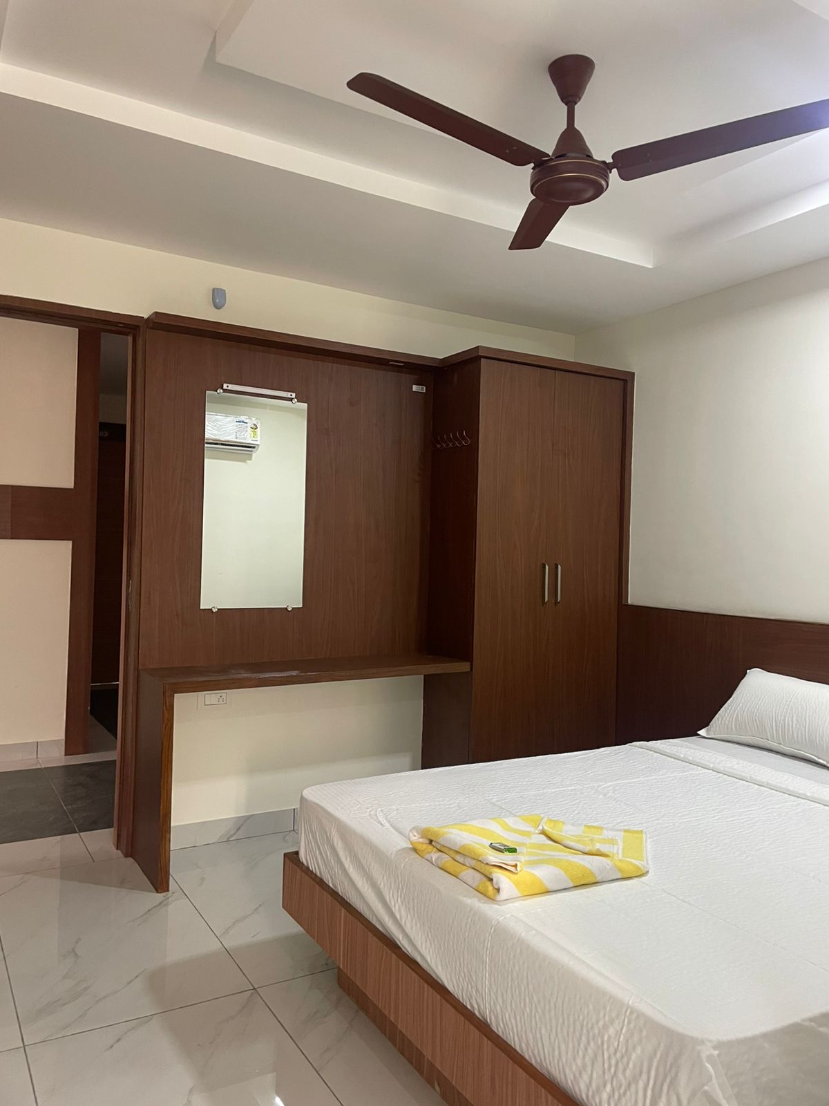 Clean and inviting hotel room showing comfortable bed and side table with lamp.